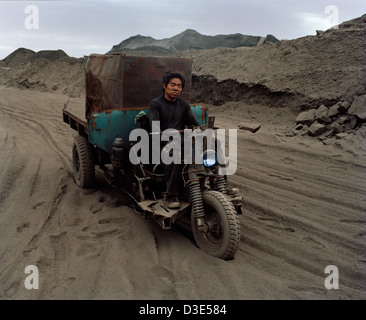 WUDA COAL FIELD, WU HAI, Innere Mongolei, CHINA - AUGUST 2007: Jin Cheng Gui, 20, treibt seine drei Rädern Pick-up entlang der staubige Feldwege Stockfoto