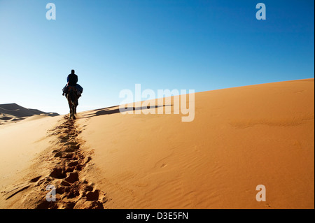 Bild des Mannes zu Fuß durch die Dünen der Wüste Stockfoto
