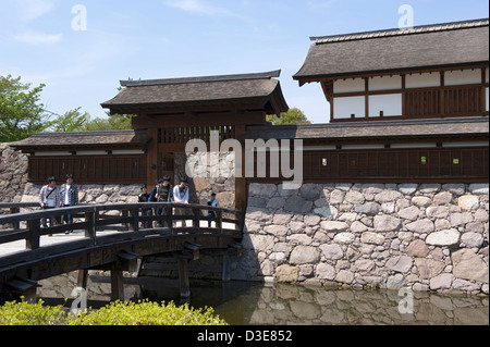 Junge Besucher über hölzerne Brücke über Graben und Kita-Akazumon bedeckt Tor am historischen Matsushiro Schloss in Nagano, Japan. Stockfoto