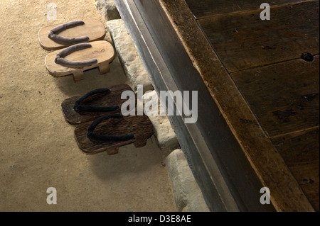 Zwei paar alte hölzerne Sandalen oder Geta, sitzen an der Schmutz Stock Eintrag Stoop oder ein historisches Wohnhaus in Japan. Stockfoto