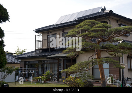 Ein Energie-effiziente Solar-Panel-Array auf die Keramik Fliesen Dach für ein Einfamilienhaus in Japan. Stockfoto