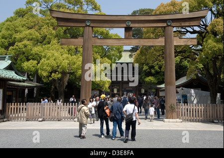 Besucher nähert sich die Zypresse aus Holz Torii Tor vor dem Haupteingang am Meiji Jingu kaiserliche Schrein in Tokio, Japan. Stockfoto