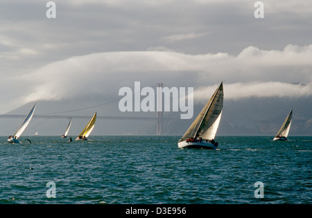 Große Boote Rennen an der San Francisco Bay in der Nähe von Nebel eingehüllt Golden Gate Bridge Stockfoto