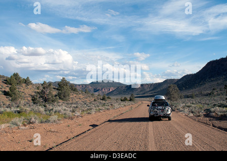 4WD Auto fährt auf einer unbefestigten Straße auf einem Roadtrip durch Owens Valley, Kalifornien in der Nähe von Bischof auf dem Weg zum Red Canyon bei Sonnenuntergang. Stockfoto