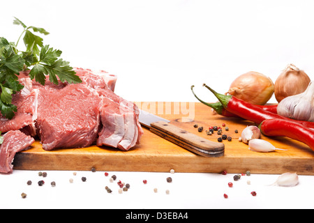 frisches Fleisch von Rindfleisch mit Knochen auf Holz mit Gewürzen und Messer Stockfoto