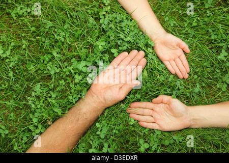 Alt, Hände Mitte Alter und junger Gras, bilden ein Dreieck, Vertretung Lebenszyklen Stockfoto