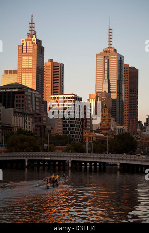 Entlang des Yarra River Rudern bei Sonnenuntergang mit Melbourne CBD im Hintergrund Victoria Australien Stockfoto