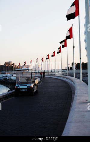 Der Pier Gehweg mit Flaggen aus dem Jumeirah Beach Hotel Marina Seafood Restaurant. Zu Fuß oder mit einem Golfbuggy Stockfoto