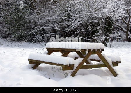 Schneebedeckte Picknickbank im Garten Stockfoto