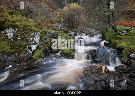 Insel der EIGG, Schottland 1. November 2007: Kenneth (Bean) Kean steht durch den Fluss, die eine 100 KW Wasserkraft Schema Ofr die Insel bietet. Stockfoto