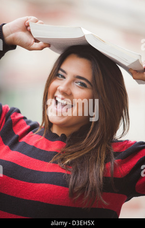 Porträt einer übergewichtigen Frau Buch auf den Kopf und lächelnd Stockfoto