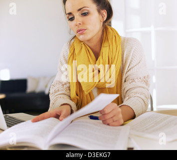 Schöne Studentin beschäftigt ihr Buch Forschung Stockfoto