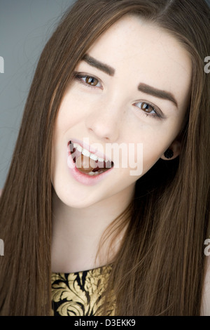 Teenager-Mädchen mit Malteser Schokolade in den Zähnen. Stockfoto