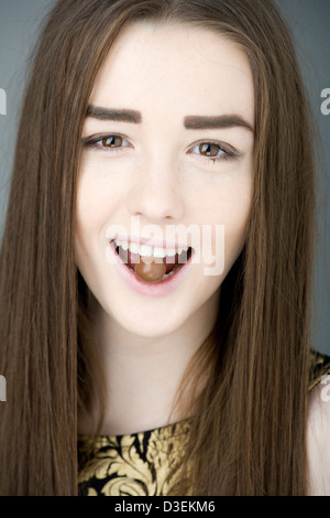 Teenager-Mädchen mit Malteser Schokolade in den Zähnen. Stockfoto