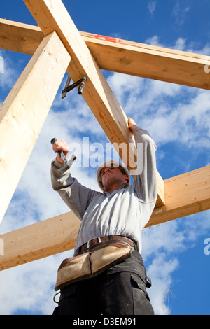 Real-Generator bei der Arbeit mit Dachkonstruktion auf der Baustelle Stockfoto