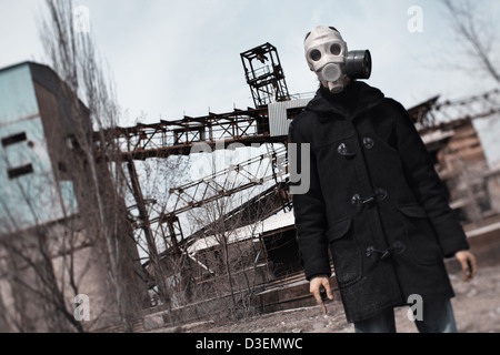 Mann in der Gasmaske Stellung in der Fabrik nach dem Tag des jüngsten Gerichts Stockfoto