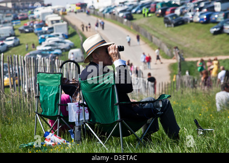 Mann sucht mit seinem Fernglas zum Royal Gehäuse Epsom Down Racecourse in England Stockfoto