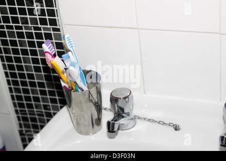 Familie Zahnbürsten in Chrom Halterung am Waschbecken Stockfoto