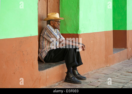 Porträt des alten kubanischen Mann sitzt vor Pastell farbigen Hausfassade in den Straßen von Trinidad, Kuba Stockfoto