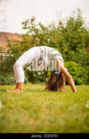 Sport auf Rasen - lächelnd kleines Kind trainieren im Freien im Garten Stockfoto