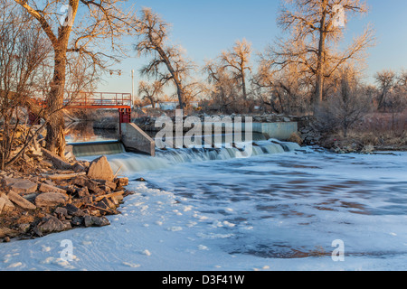 kleine Talsperre Umleitung von Wasser zur Bewässerung von Ackerland - South Platte River in der Nähe von Fort Lupton, Colorado, Winterlandschaft bei Sonnenuntergang Stockfoto