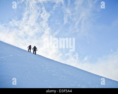 Zwei Bergsteiger am Schneehang in Schottland im Winter Stockfoto