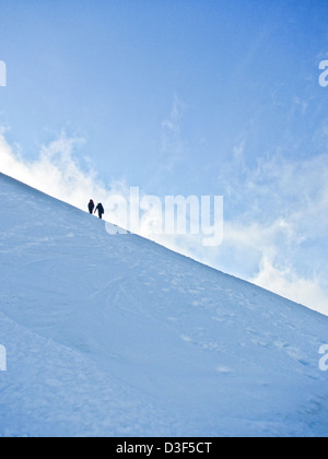 Zwei Bergsteiger am Schneehang in Schottland im Winter Stockfoto