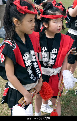 Zwei kleine Mädchen tragen rote Stirnbänder und Happi Mäntel teilhaben an Feierlichkeiten bei Sagami keine Otako Matsuri Riesen Drachenfest Stockfoto