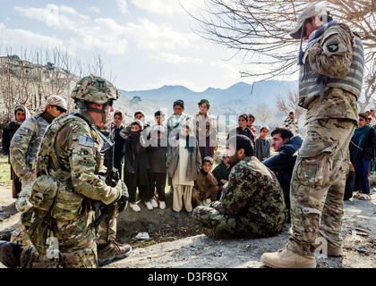 Afghanische Kinder versammeln, um als US-Soldaten treffen mit Soldaten der afghanischen Nationalarmee in einem abgelegenen Dorf 13. Januar 2013 in Khowst Provinz, Afghanistan zu sehen. Stockfoto