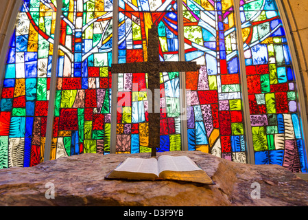 Ein Kreuz und Bibel vor Glasmalerei Stockfoto