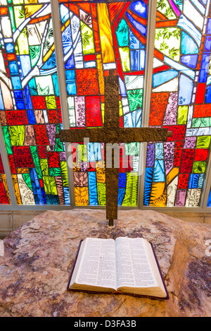 Ein Kreuz und Bibel vor Glasmalerei Stockfoto