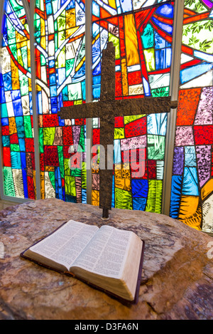 Ein Kreuz und Bibel vor Glasmalerei Stockfoto