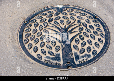 Künstlerische Kanaldeckel in der Stadt von Sagami, Präfektur Kanagawa zeigt einen Baum mit Blättern. Stockfoto