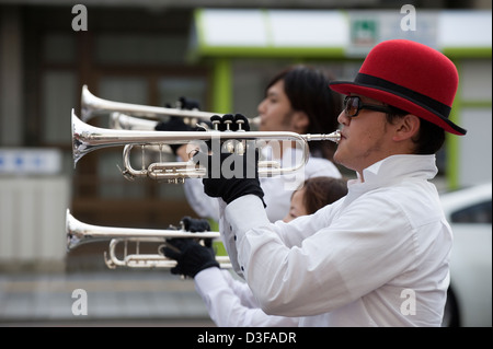 Trompeter, einschließlich Kerl mit roten Bowler-Hut und eine Sonnenbrille, im Western-Stil Blaskapelle beim Festival, Japan. Stockfoto