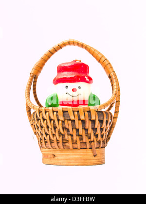 Puppe Weihnachtskerze Schnee und einen gelben Weidenkorb isoliert auf weißem Hintergrund Stockfoto