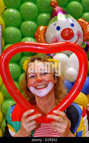 (Dpa) - Leela Bergmann ist gekleidet wie ein Clown und Blick durch einen Ballon in der Form eines Herzens auf der "Inter-Karnival" in Köln, Deutschland, 11. Juli 2003 Messe. Die Messe bietet Kostüme und andere Neuheit-Produkte für die Karnevalssaison. Mehr als 1 Million Produkte ausgestellt und präsentieren auf der Messe mit rund 150 Ausstellern angekommen sind. Stockfoto