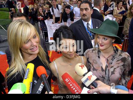 (Dpa) - Schauspielerinnen Cameron Diaz, Lucy Liu und Drew Barrymore (L-R), Hauptfiguren in dem neuen Film "Charlie's Angels Full Throttle", sind Interviews zu geben auf dem Weg zu einem Kino in Berlin, 8. Juli 2003. Mit ihrem Charme begeistert die Hollywood-Stars Besucher bei der Premierenfeier. Stockfoto