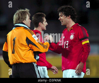 (Dpa) - deutsche Mittelfeldspieler und Team-Kapitän Michael Ballack (R) lächelt und schüttelt die Hand mit Torhüter Oliver Kahn (L) nach dem Ende des Freundschaftsspiel zwischen Japan und Deutschland im internationalen Stadium in Yokohama, Japan, 16. Dezember 2004. In den Hintergrund der deutsche Stürmer Miroslav Klose ersichtlich. Deutschland gewann das erste Spiel von seinen drei Spiel-Tour durch Asien mit einem Endstand von Stockfoto