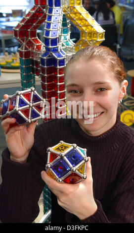 (Dpa) - Anja Lehnis zeigt zwei alte Gegenstände vor einem zwei Meter hohen Turm der magnetische Geomag Teile im Spielzeugmuseum in Chemnitz, Deutschland, 10. Dezember 2004 gemacht. Die Konstruktion besteht aus Magnetleisten und Metallkugeln, die zusammenhalten farbige Kunststoffplatten in verschiedenen geometrischen Formen. Stockfoto