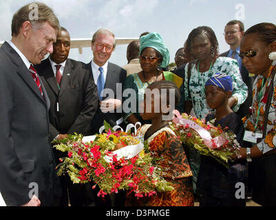 (Dpa) - eine Mädchen mit Blumen begrüßt Bundespräsident Horst Köhler am internationalen Flughafen in Freetown, Sierra Leone, 6. Dezember 2004. Sierra Leone ist die erste Station des Bundespräsidenten 11-tägigen Afrika-Reise. Stockfoto