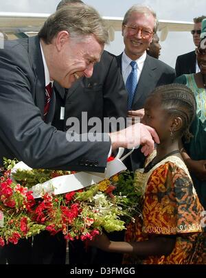 (Dpa) - eine Mädchen mit Blumen begrüßt Bundespräsident Horst Köhler am internationalen Flughafen in Freetown, Sierra Leone, 6. Dezember 2004. Sierra Leone ist die erste Station des Bundespräsidenten 11-tägigen Afrika-Reise. Stockfoto