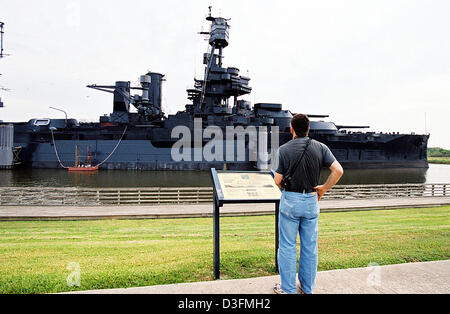 (Dpa) - ein Tourist schaut das Kriegsschiff "Texas", ein ehemaliges Schlachtschiff der US Navy, 2. September 2004 in Houston, Texas/USA, vor Anker liegen. Das Schiff der Dreadnought-Klasse ist fast ein Jahrhundert alt. Es machte seine Jungfernfahrt am 18. Dezember 1912 und ging zwei Jahre später in regelmäßigen Service. Mit einer Länge von 180 Metern war es eines der größten Kriegsschiffe in der Geschichte. Stockfoto