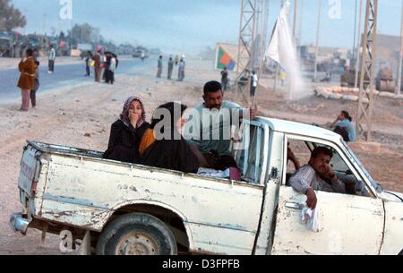 (Dpa) - Welle irakische Zivilisten in einem Pick-up-Truck eine weiße Fahne ca. 15 km südlich von Bagdad, Irak, 4. April 2003. Die Koalitionskräfte sind in Richtung der irakischen Hauptstadt, während der Luftangriffe auf die Hauptstadt und anderen Städten weiter. Stockfoto