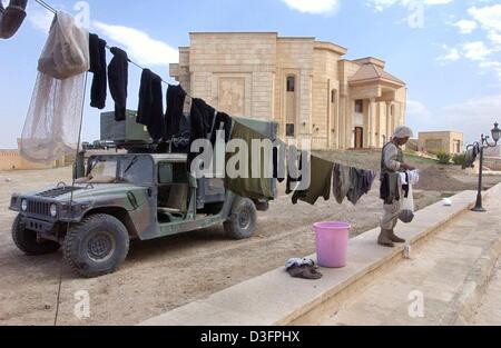 (Dpa) - eine US-Marine auflegt seine Wäsche vor der ehemaligen Sommerresidenz von Saddam Hussein im nördlichen irakischen Stadt Tikrit, 14. April 2003. Tikrit, der Heimatstadt von Saddam, war das letzte Bollwerk seines Regimes, deren Fall das effektive Ende des Krieges markieren würde. Stockfoto