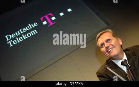 (Dpa) - Kai-Uwe Ricke, Vorstandsvorsitzender der Deutschen Telekom AG, der deutschen Telekommunikations-Unternehmen, lächelt während einer Pressekonferenz mit dem Firmenlogo in Hannover, Deutschland, 10. März 2003 im Hintergrund projiziert. Kai-Uwe Ricke sagt, dass das Geschäftsjahr 2002 war eines der schwierigsten Jahre in der Geschichte des Unternehmens und auch die schlimmsten in der Geschichte der deutschen Wirtschaft Stockfoto