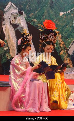 (Dpa) - zwei schöne Damen einer ethnischen Minderheit aus China tragen reich verzierte Kleider und sitzen auf dem Messestand von China auf der internationalen Tourismus Messe in Berlin, Deutschland, 10. März 2003. Stockfoto