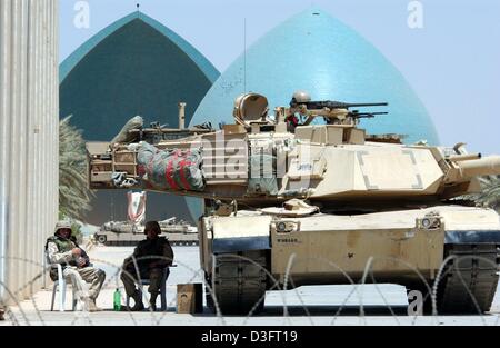 (Dpa) - US-Soldaten sitzt neben einem Tank versuchen Schutz vor der Sonne vor das Denkmal von Saddams Qadissiya Märtyrer in Bagdad, 6. Mai 2003. Die Temperatur in Bagdad wirft bis zu über 40 Grad. Stockfoto