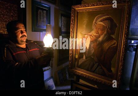 (Dpa) - Ahmed Sauri, Besitzer der Kapitän Art Gallery, eine Öllampe in der Hand hält und einem alten Gemälde in der Kunstgalerie in Bagdad, Irak, 2. Mai 2003 beleuchtet. Rund 650 Kunstwerke aus geplünderten irakischen Nationalmuseums in Bagdad haben tauchte wieder auf. Unterdessen hat ein führender britischer Archäologe seine Meinung geäußert, dass im Irak Museum im Auftrag Internat geplündert haben kann Stockfoto