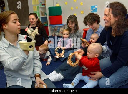 (Dpa) - Schule Musik Pädagogin Silke Kratzsch (L) arbeitet mit Kleinkinder und deren Mütter in einem Pilotprojekt in early Education an den an der Yamaha Music in Chemnitz, Ostdeutschland, 22. Januar 2003.  Die Kinder werden ermutigt, spielerisch die Welt der Musik durch singen und Lieder hören, tanzen, und Trommel und Tamorine spielen zu erkunden.  Ca. Stockfoto