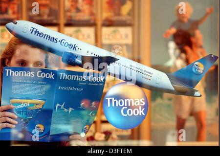 (Dpa) - eine junge Frau schöpft durch Thomas Cook Reisekatalog in einem Reisebüro in Frankfurt am Main, 19. Februar 2003. Thomas Cook ist der zweitgrößte Reiseunternehmen in Deutschland und zum ersten Mal der Reds. Die Reisebranche erlebt schwierige Zeiten, wie Verbraucher in Europa wurde ihr Reisebudget einschränken, haben. Thomas Cook im Geschäftsjahr erfasst ein Stockfoto